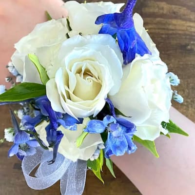 White rose bouquet with blue flowers and a silver ribbon
