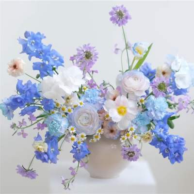 Pastel blue and lavender floral arrangement in a pale vase