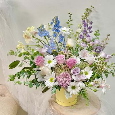 Pastel mixed flower arrangement in a yellow vase