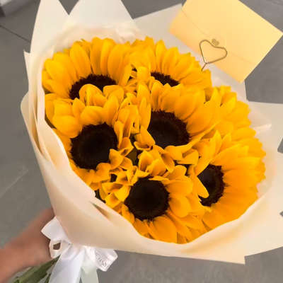Bouquet of yellow sunflowers wrapped in white paper
