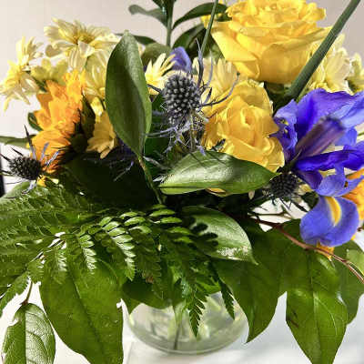 Yellow and blue mixed bouquet in a clear glass vase