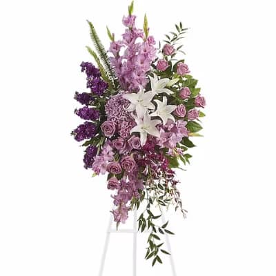 Tall standing floral spray with white lilies, lavender roses, and purple flowers