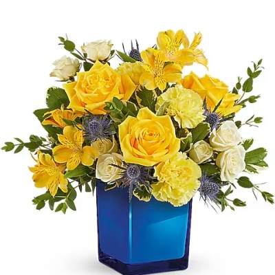 Yellow roses and white flowers in a blue glass vase