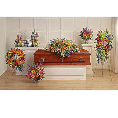 Colorful funeral casket spray with standing floral arrangements