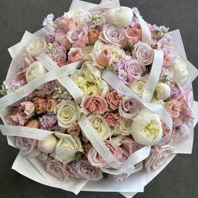 Large pastel bouquet of roses and peonies wrapped in white paper