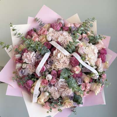 Large bouquet of pink and cream roses with pastel wrapping