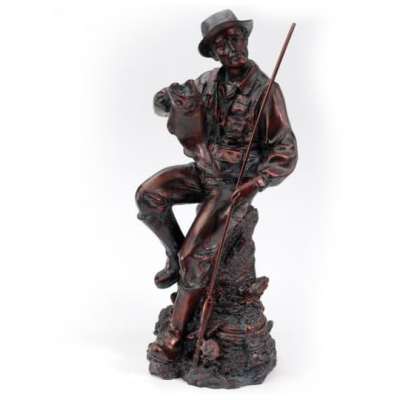 Dark brown figurine of a seated fisherman holding a large fish and fishing rod