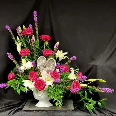 Pink roses and white lilies in a white urn vase