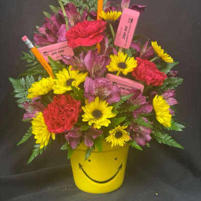 Bright mixed bouquet in a yellow smiley-face pot