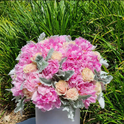 Pink floral arrangement in a white cylindrical vase