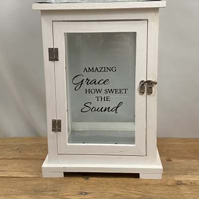 White lantern with glass door and "Amazing Grace" text