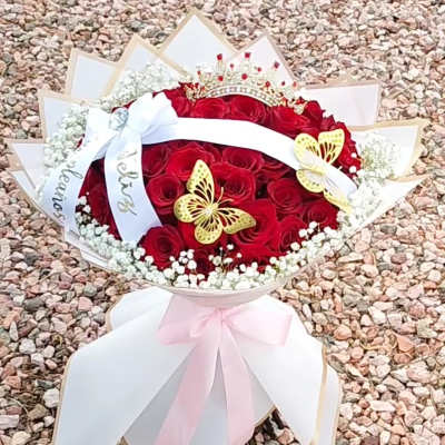 Red rose bouquet with white ribbon, butterflies, and a crown topper