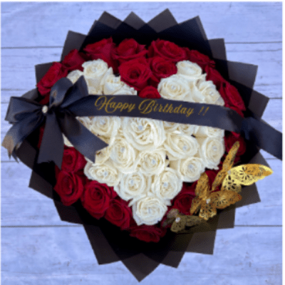 Heart-shaped bouquet of red and white roses with a birthday ribbon
