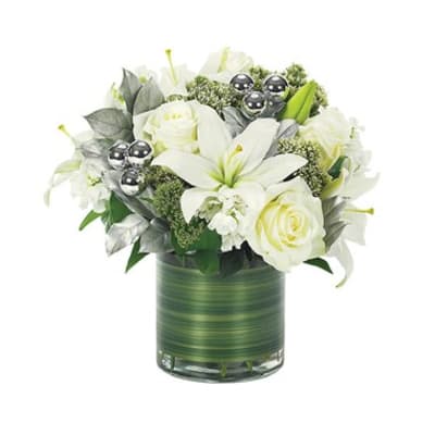 White lilies and roses in a green glass vase with silver accents