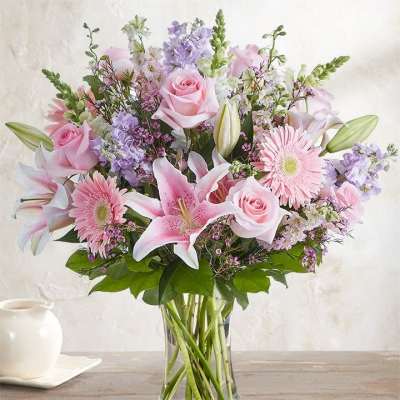 Pink roses and lilies in a clear glass vase