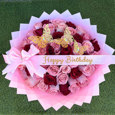 Pink and red rose bouquet with butterfly decorations and a Happy Birthday ribbon