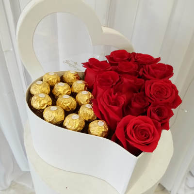 Heart-shaped box with red roses and gold-wrapped chocolates