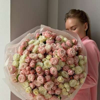 Large bouquet of pale pink and cream roses wrapped in tissue paper