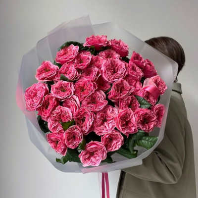 Large bouquet of bright pink roses wrapped in translucent paper