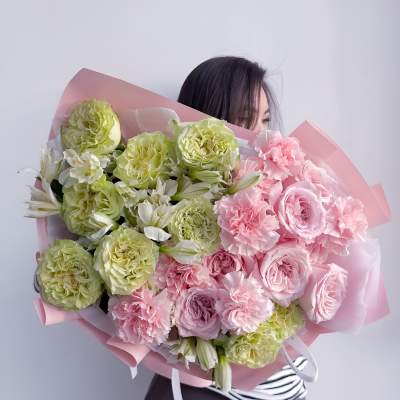 Large bouquet of pink and green flowers wrapped in pink paper
