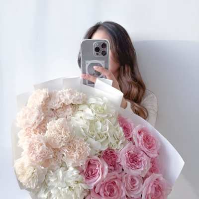 Woman holding a large bouquet of pink and white flowers