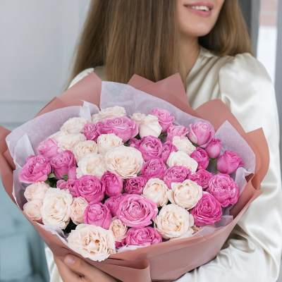 Bouquet of pink and blush roses wrapped in pink paper