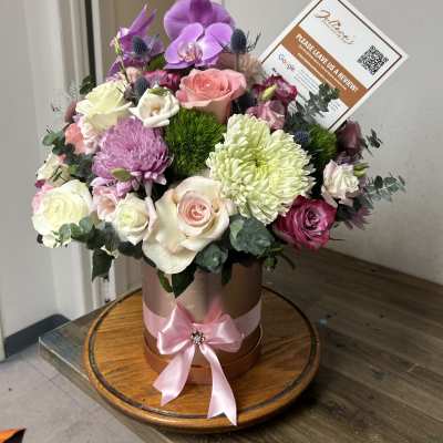 Mixed bouquet in a round hatbox with pink ribbon