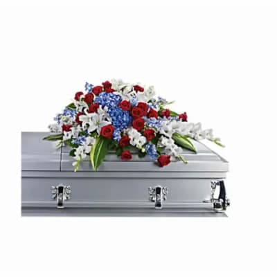 Red, white, and blue casket spray with lilies and roses on a silver casket