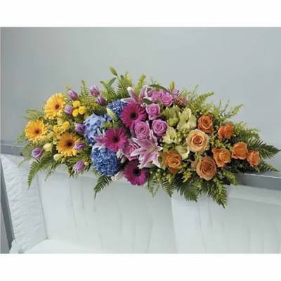 Colorful casket spray with pink lilies, roses, gerbera daisies, hydrangeas, and mixed blooms.