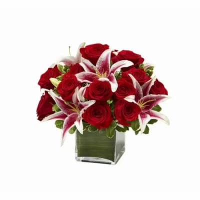 Compact arrangement of red roses and white-pink lilies in a clear glass cube vase