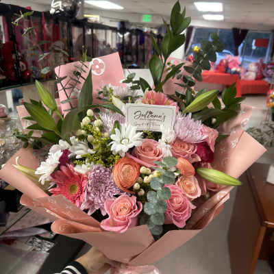 Pink and white mixed bouquet with roses and daisies wrapped in pink paper