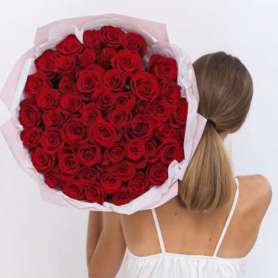 Large bouquet of red roses wrapped in pale pink and white paper