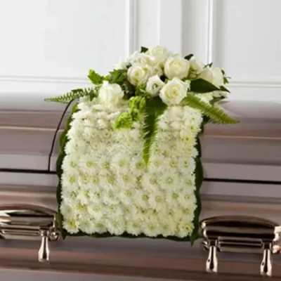 White floral casket spray with roses and chrysanthemums