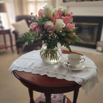 Pink and white rose bouquet in a clear glass vase on a table
