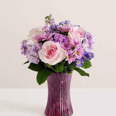 Pink and lavender bouquet in a purple glass vase