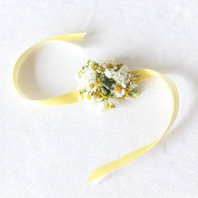 Small white and yellow floral wrist corsage with ribbon ties