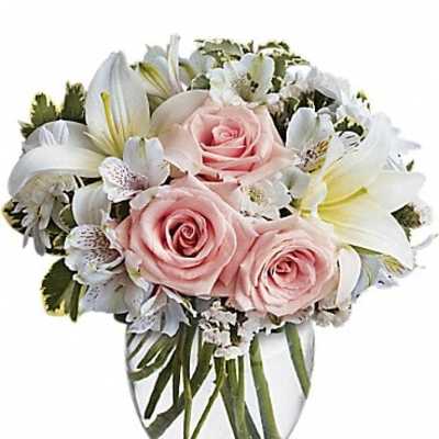 Pink roses and white lilies in a clear glass vase