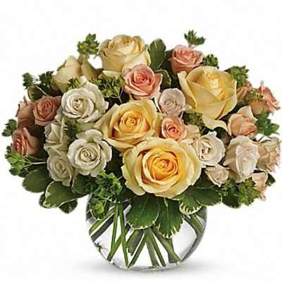Bouquet of cream, peach, and yellow roses in a clear glass vase