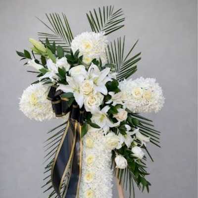 White floral standing spray with lilies and roses on an easel