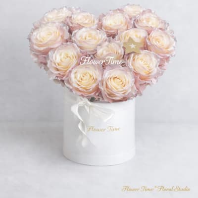 Heart-shaped bouquet of pale pink roses in a white box