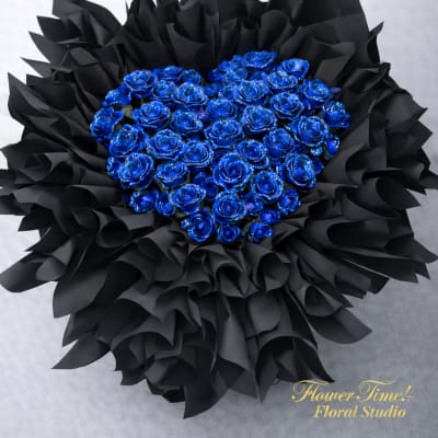 Heart-shaped bouquet of blue roses wrapped in black paper
