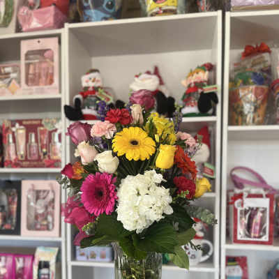 Mixed bouquet of bright flowers in a clear glass vase