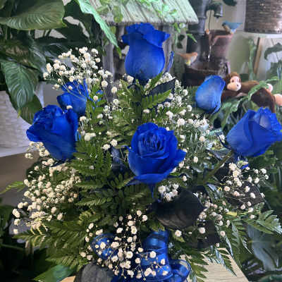 Blue roses with baby's breath in a glass vase