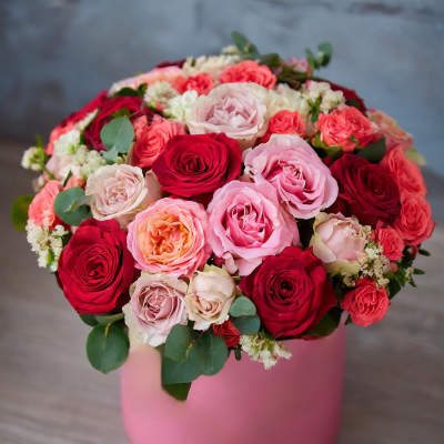 Bouquet of pink and red roses in a pink hat box