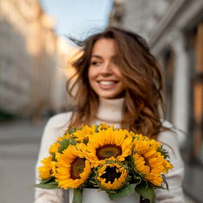 Woman holding a white box filled with sunflowers