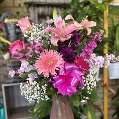 Pink bouquet with lilies, gerbera daisy, and a bright ribbon in a vase