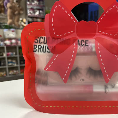 Red bow-shaped gift package with false eyelashes inside