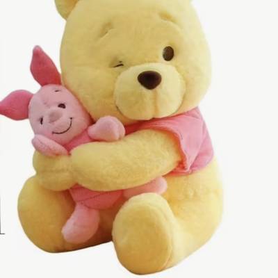 Yellow teddy bear hugging a pink pig plush toy