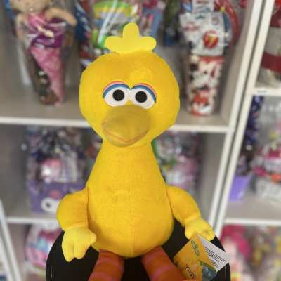 Yellow plush bird toy with orange feet and a tag
