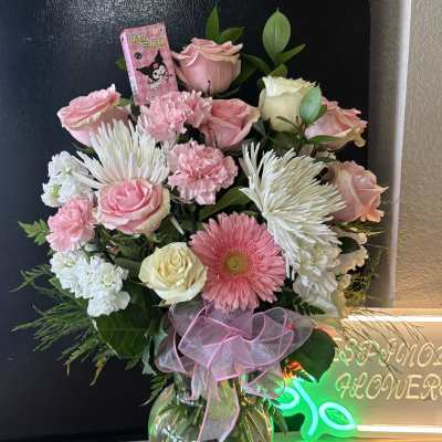 Pink and white mixed flower bouquet in a glass vase with a ribbon